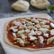 Pizza z nałożonymi składnikami przed upieczeniem